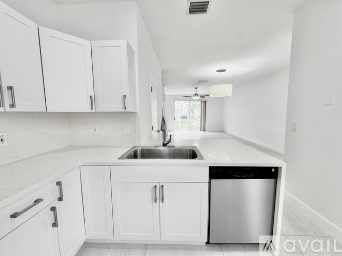 A kitchen with white cabinets and a stainless steel dishwasher.