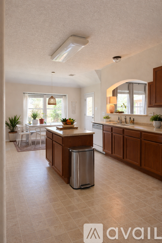 A kitchen with a trash can in the middle of the room.
