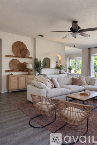 A living room with a white couch, a wooden coffee table, and a ceiling fan.