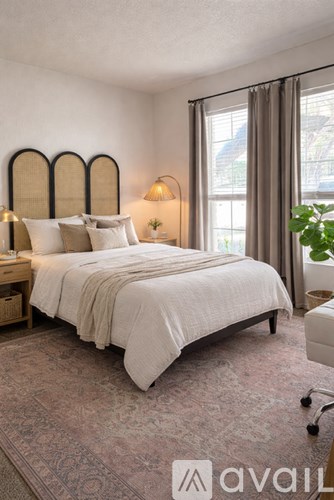 A bedroom with a large bed and a window with curtains.