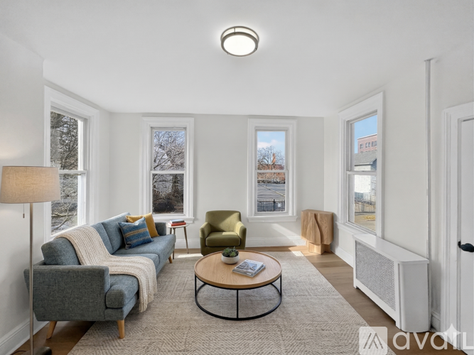 A living room with a grey couch, a green armchair, a coffee table, and a lamp.