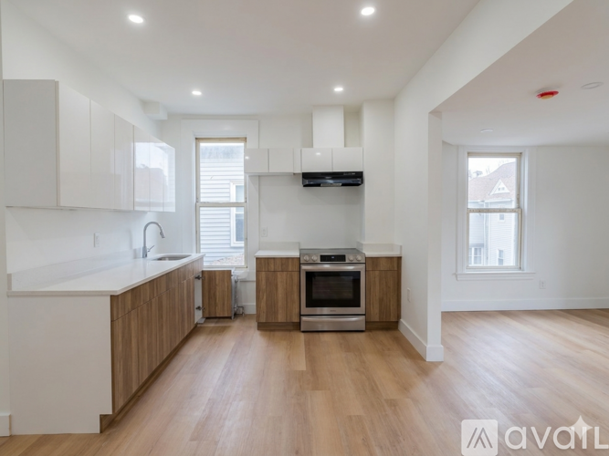 A modern kitchen with wooden floors and white walls.