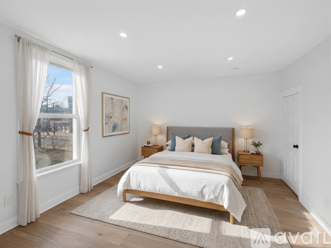 A bedroom with a large bed and a view of a snowy landscape outside the window.