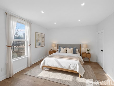 A bedroom with a large bed and a view of a snowy landscape outside the window.