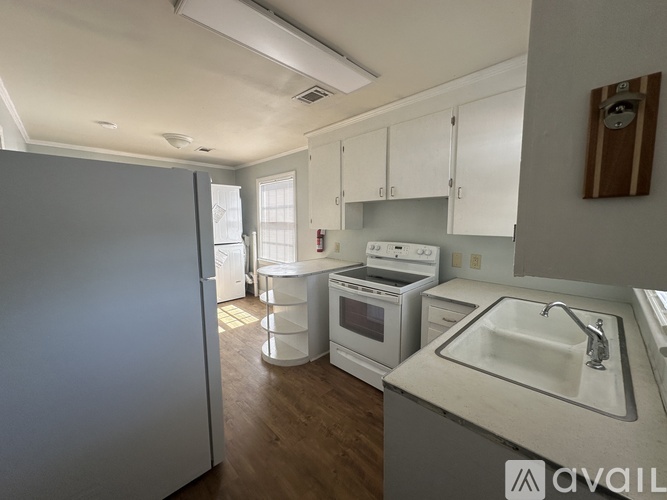 A kitchen with white cabinets and a white sink.