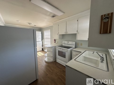A kitchen with white cabinets and a white sink.