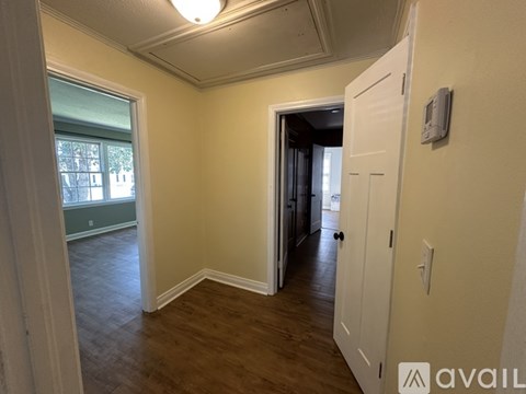 A room with a white door and a window with a view of a building outside.