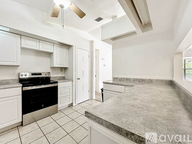 A kitchen with white cabinets and a black stove top oven.