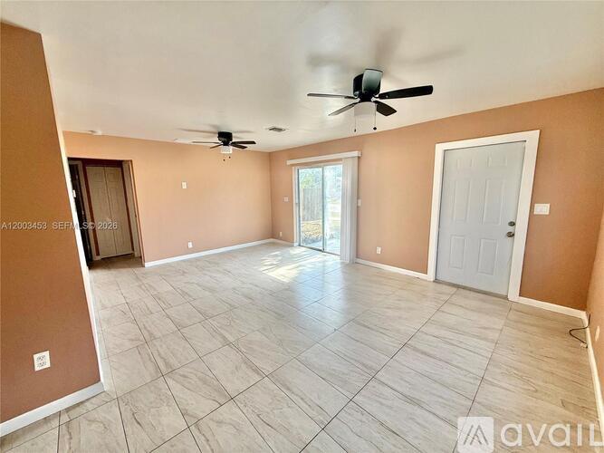 A spacious room with a ceiling fan and tile flooring.