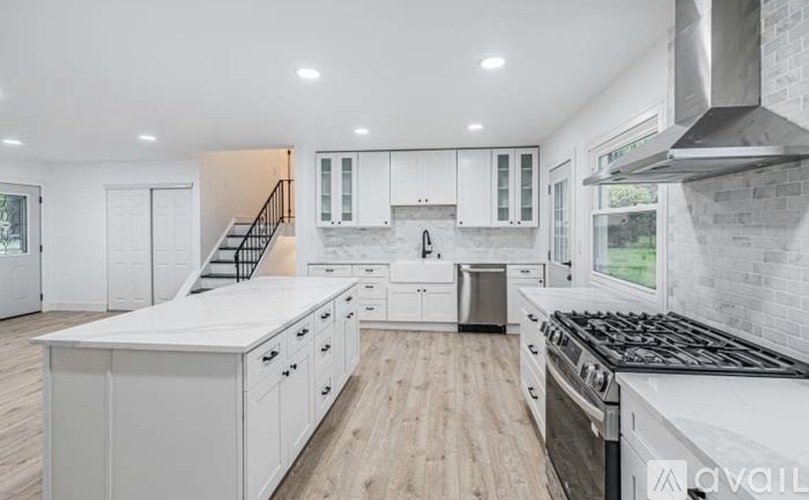 A modern kitchen with white cabinets and a stainless steel stove.