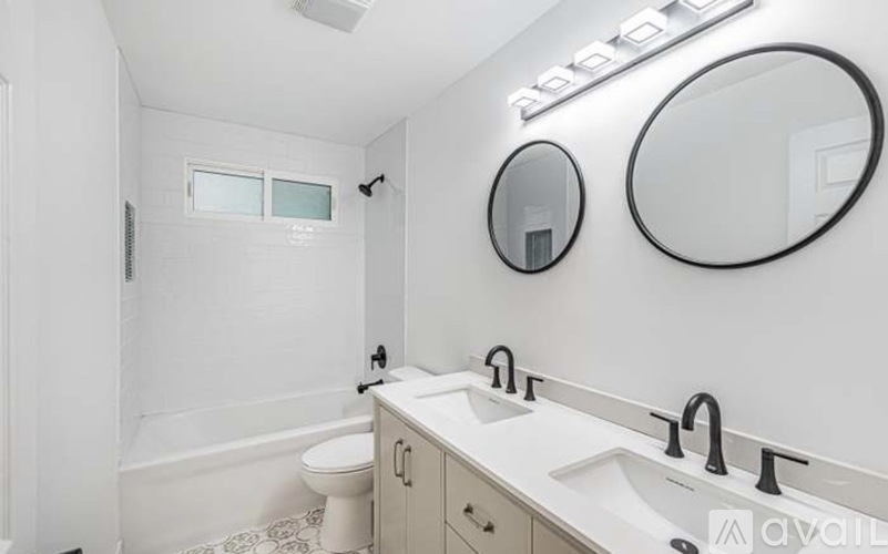 A white bathroom with a toilet, sink, and mirror.