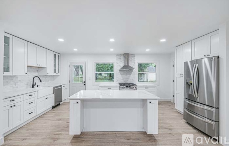 A modern kitchen with white cabinets and a large island.