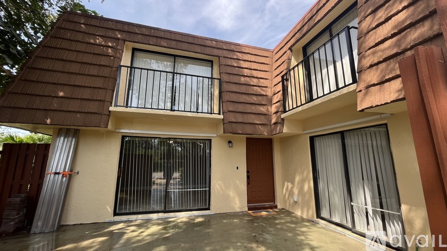 A two-story house with a balcony on the second floor.