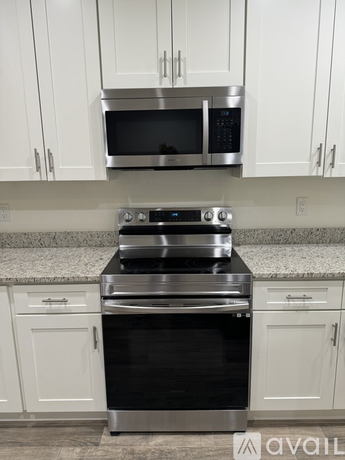 A kitchen with white cabinets and a granite countertop.