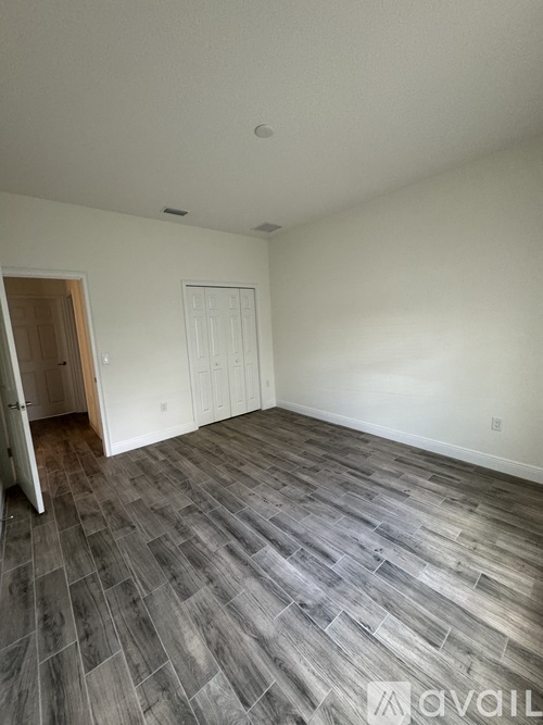 A room with a wooden floor and white walls.