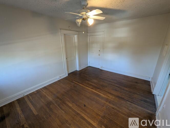 A room with wooden floors and a ceiling fan.