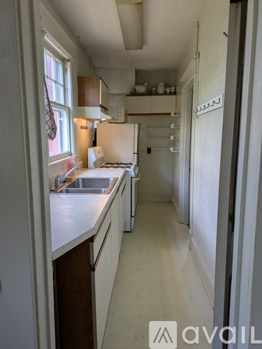A kitchen with white cabinets and a white fridge.