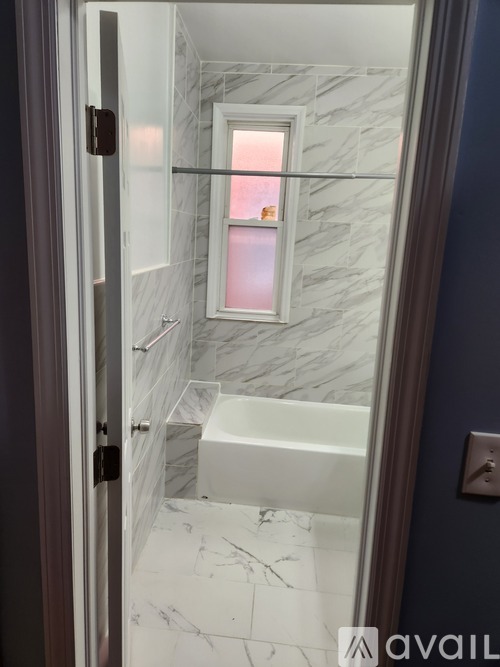 A bathroom with a marble floor and a window.