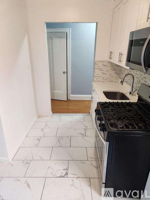 A kitchen with a black stove top oven and a sink.