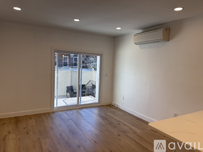 A room with a sliding glass door leading to a balcony.