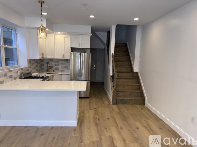 A kitchen with a refrigerator, stove, and cabinets.