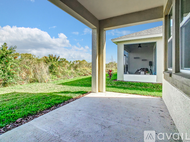 A patio area of a house with a view of a grassy field.