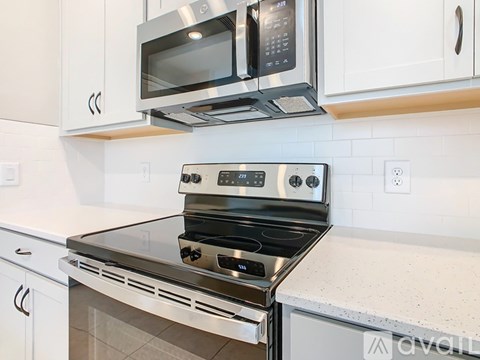 A modern kitchen with a stove and microwave oven.