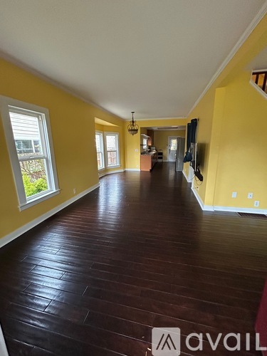 A long hallway with wood floors and yellow walls.