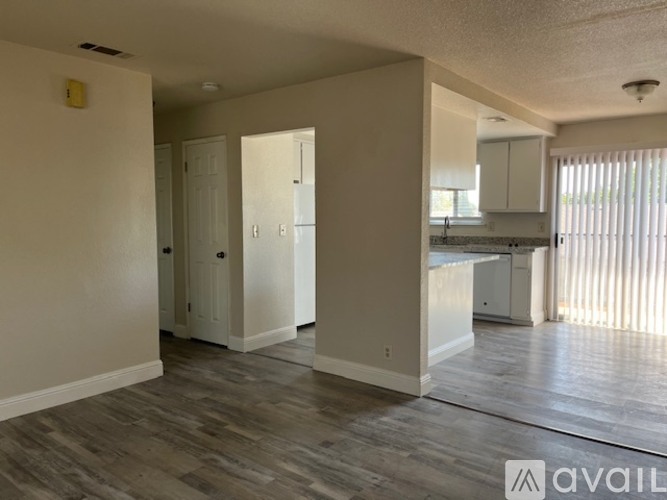 A spacious living area with a kitchen in the background.