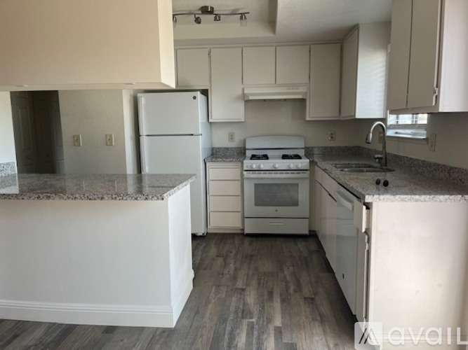 A kitchen with white appliances and cabinets.