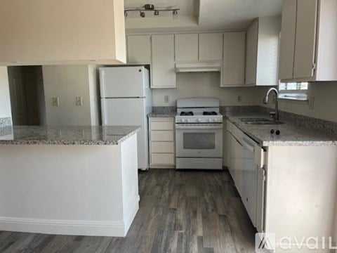 A kitchen with white appliances and cabinets.