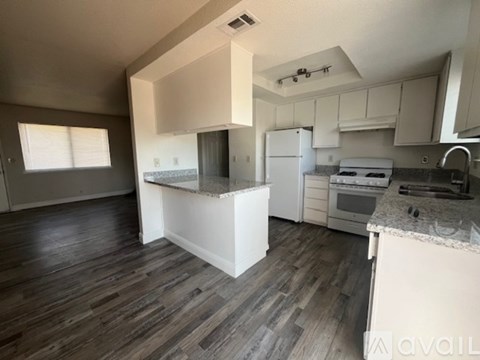 A kitchen with a white island and wooden floors.