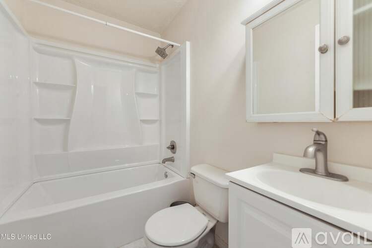 A white bathroom with a toilet, sink, and bathtub.