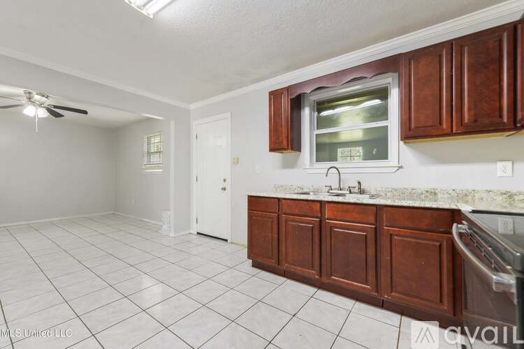 A kitchen with white tiles and wooden cabinets is available for rent.