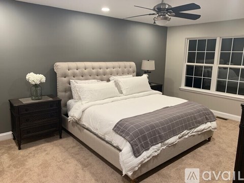 A bedroom with a large bed and a ceiling fan.
