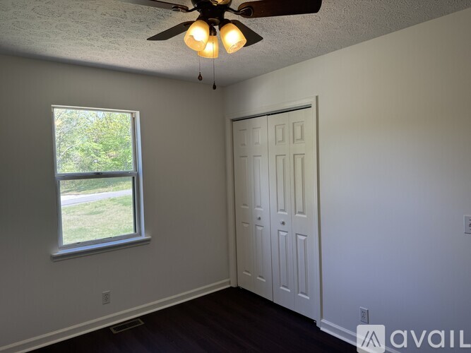A room with a ceiling fan and a window.