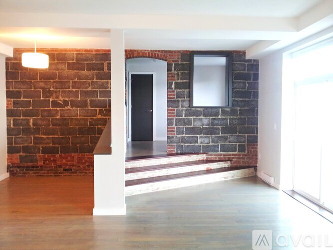 A room with a brick wall and a white door.