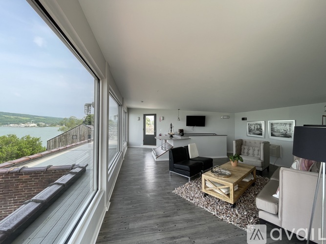 A living room with a view of the water and a balcony.