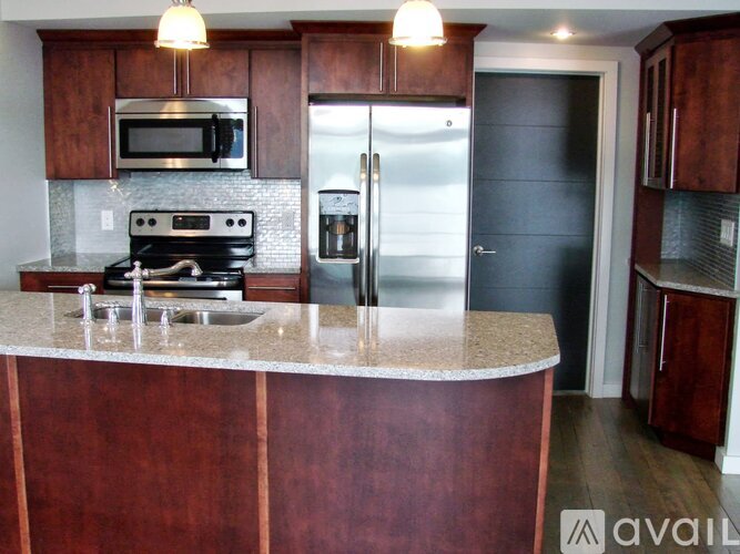 A kitchen with a refrigerator, microwave, and oven.