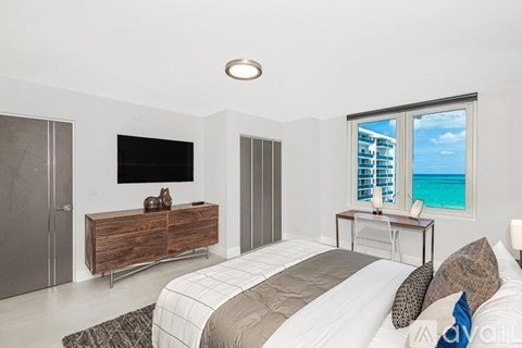 A bedroom with a large bed and a flat screen TV mounted on the wall.