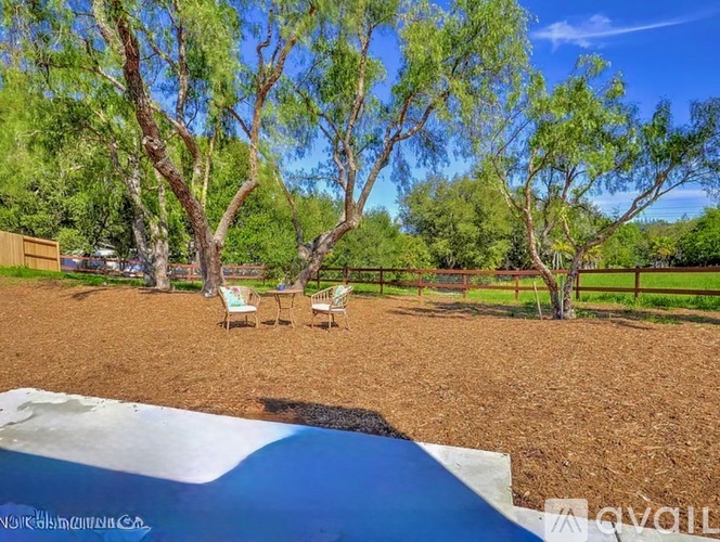 A backyard with a pool and a fence.