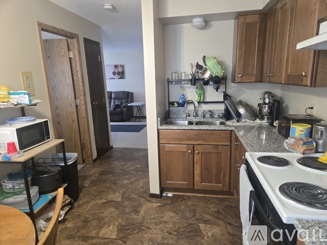A kitchen with a stove, sink, and cabinets.