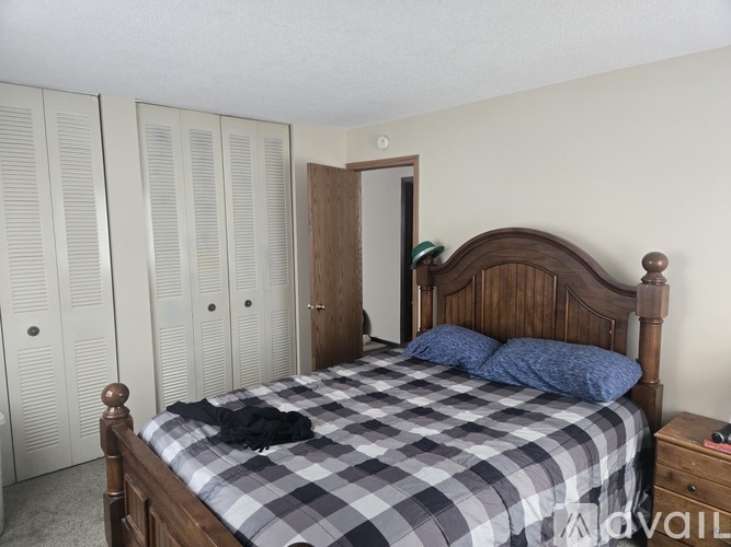 A bedroom with a bed, dresser, and wardrobe.