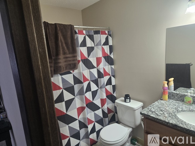 A bathroom with a toilet, sink, and shower curtain.