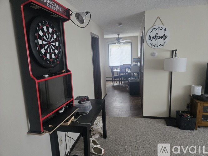 A room with a dartboard and a welcome sign.