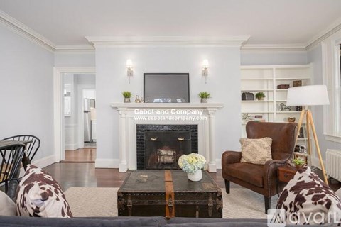 A living room with a fireplace and a television on the wall.