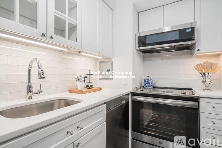 A modern kitchen with a stainless steel oven and white cabinets.