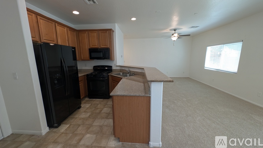 A kitchen with black appliances and wooden cabinets.