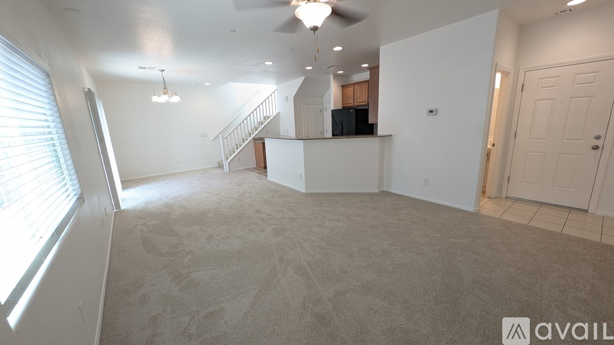 A spacious living room with a staircase leading to the upper floor.