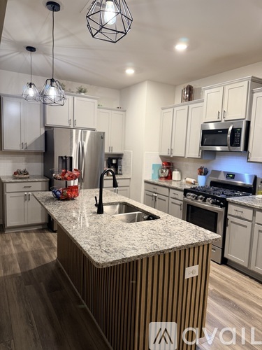 A modern kitchen with a central island and stainless steel appliances.